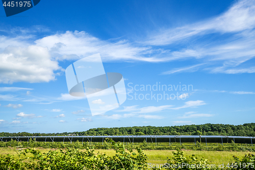 Image of Solar cell park on a green field with blue sky