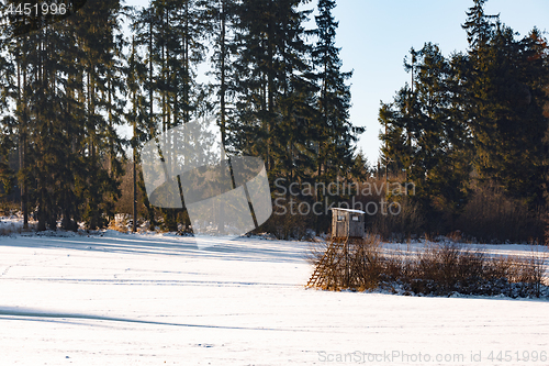 Image of winter frozen landscape with hunting tower on highland