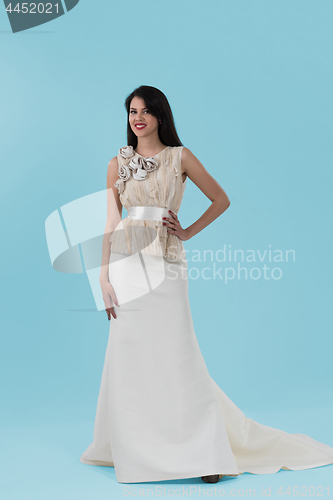 Image of beautiful woman wearing wedding dress against cyan background