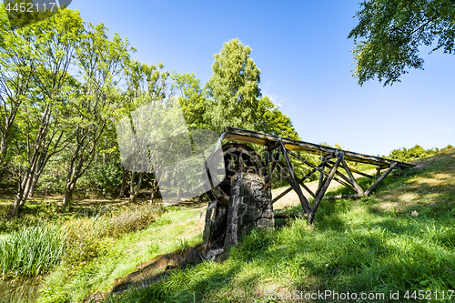 Image of Old water mill on a meadow with green grass