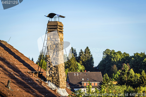 Image of Old chimney with a ladder on a roof