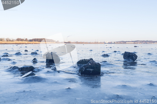 Image of Black rocks in the ice on a frozen lake