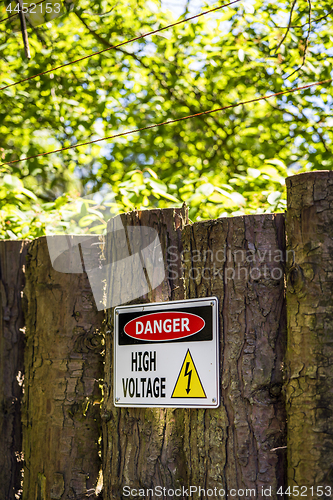 Image of High voltage sign on a wooden fence