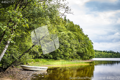 Image of Boat at a river shore surrounded by a forest