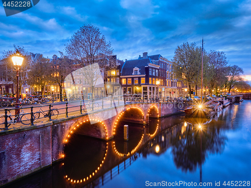 Image of Amterdam canal, bridge and medieval houses in the evening