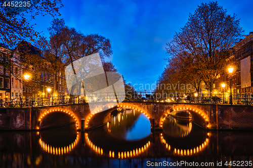 Image of Amterdam canal, bridge and medieval houses in the evening