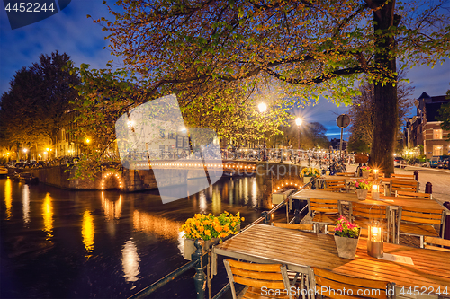 Image of Amterdam cafe tables, canal, bridge and medieval houses in the e