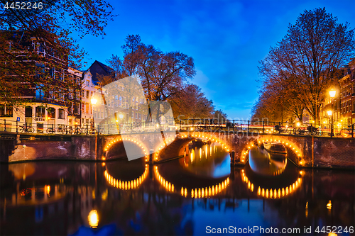 Image of Amterdam canal, bridge and medieval houses in the evening