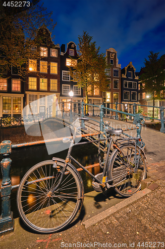 Image of Amterdam canal, bridge and medieval houses in the evening