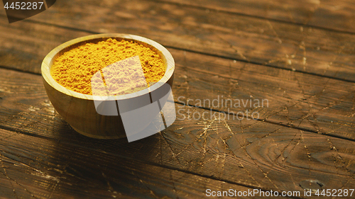 Image of Small bowl of orange turmeric spice