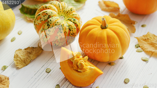 Image of Yellow pumpkins and dried leaves