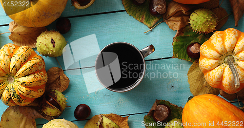 Image of Cup of coffee surrounded by pumpkins