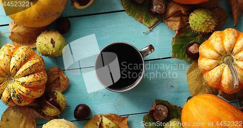 Image of Cup of coffee surrounded by pumpkins