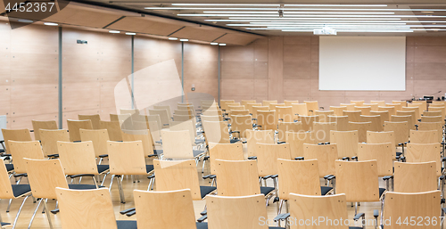 Image of Empty wooden seats in a cotmporary lecture hall.