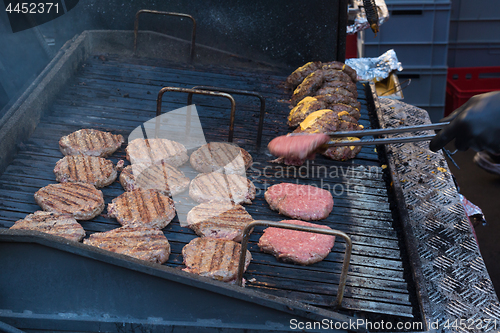 Image of Chef making beef burgers outdoor on open kitchen international food festival event.