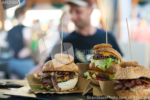 Image of Chef making beef burgers outdoor on open kitchen international food festival event.