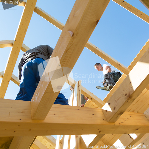 Image of Builders at work with wooden roof construction.