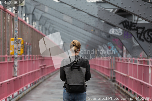 Image of Solo casual woman walking the cycling lane on Williamsburg Bridge, Brooklyn, New York City, USA