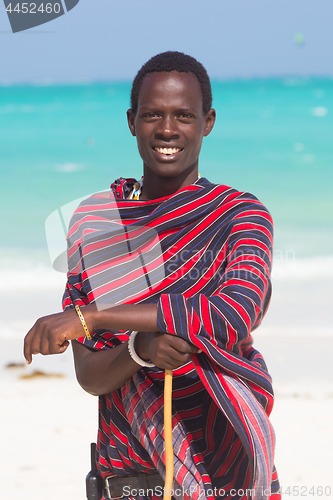 Image of Traditonaly dressed maasai black man on picture perfect tropical Paje beach, Zanzibar, Tanzania, East Africa.