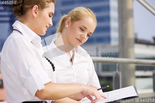 Image of two happy businesswomen with paper chart