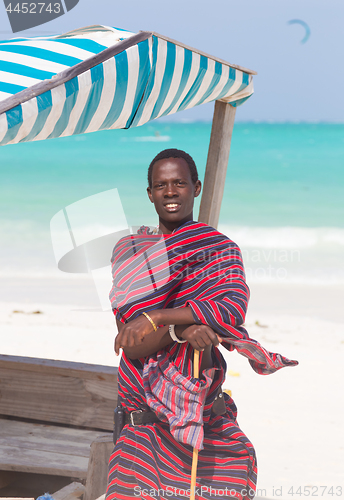 Image of Traditonaly dressed maasai black man on picture perfect tropical Paje beach, Zanzibar, Tanzania, East Africa.