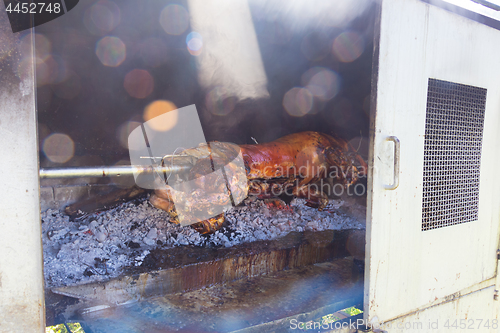 Image of Traditional balkan dish - whole piglet grilled on the open fire.