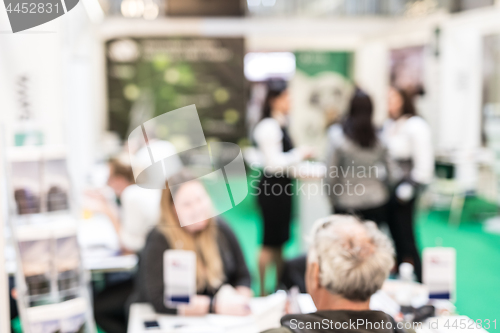 Image of Anonymous blurred people discussing business at a trade fair.