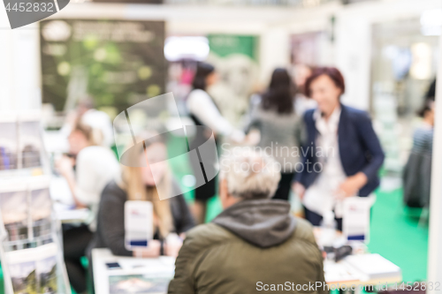 Image of Anonymous blurred people discussing business at a trade fair.