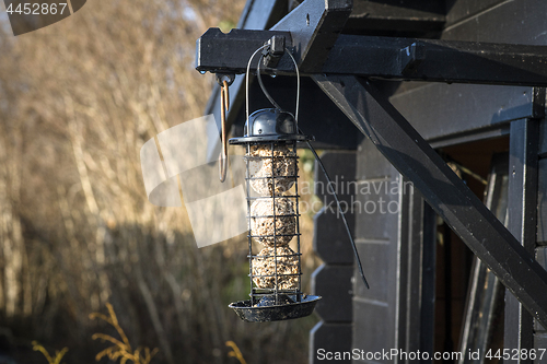 Image of Bird feeder cage on a wooden shed