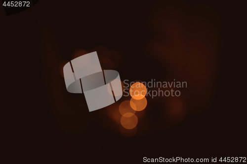 Image of Bokeh lights in orange golden colors on brown background