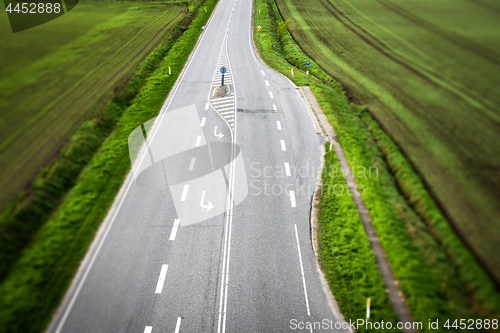 Image of Highway road with white stripes with rural fields