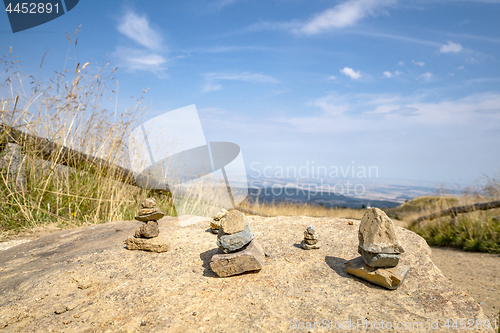 Image of Small pebble stacks balancing on a large rock