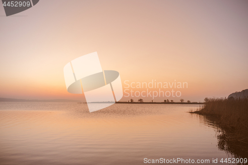 Image of Sunrise by a lake with silhouettes