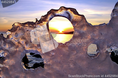 Image of View of winter sunset through holes in ice