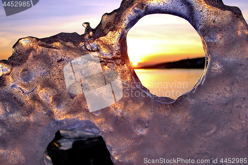 Image of View of winter sunset through holes in ice