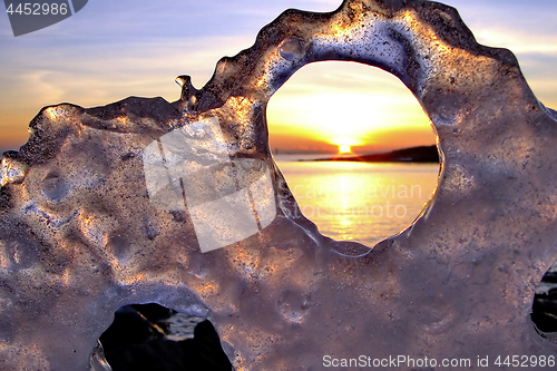 Image of View of winter sunset through holes in ice