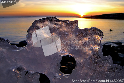 Image of View of winter sunset through holes in ice
