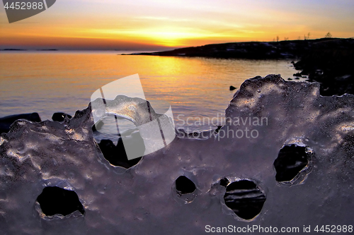 Image of View of winter sunset through holes in ice
