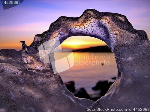 Image of View of winter sunset through holes in ice