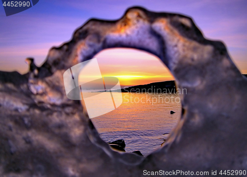 Image of View of winter sunset through holes in ice