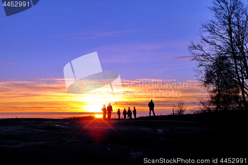 Image of Dark silhouettes of people on winter sunset background