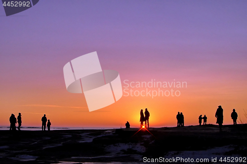 Image of Dark silhouettes of people on winter sunset background