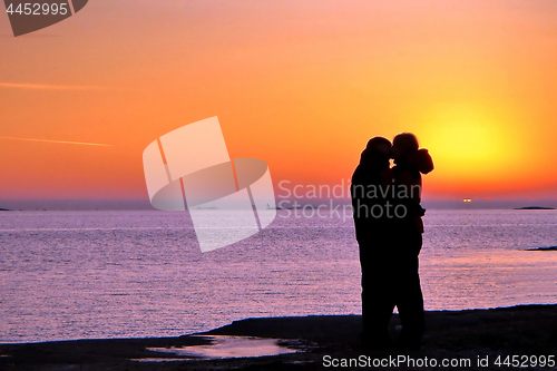 Image of Dark silhouettes of people on winter sunset background