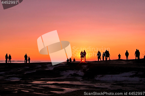 Image of Dark silhouettes of people on winter sunset background