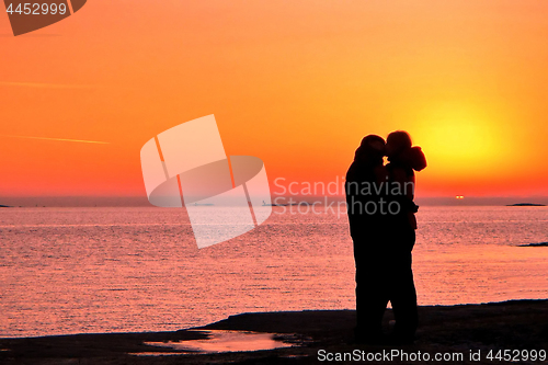 Image of Dark silhouettes of people on winter sunset background