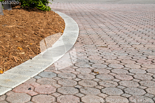 Image of curved low angle brick paver driveway with mulch