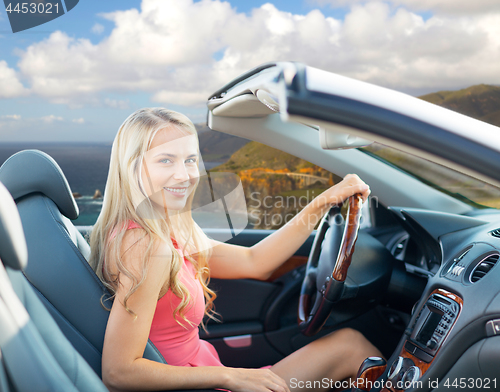 Image of woman driving convertible car on big sur coast