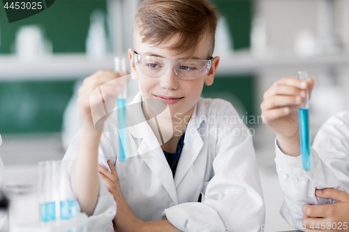 Image of boy with test tube studying chemistry at school