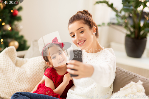 Image of family taking selfie by smartphone at home