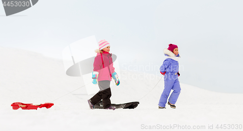 Image of happy little girls with sleds walking in winter